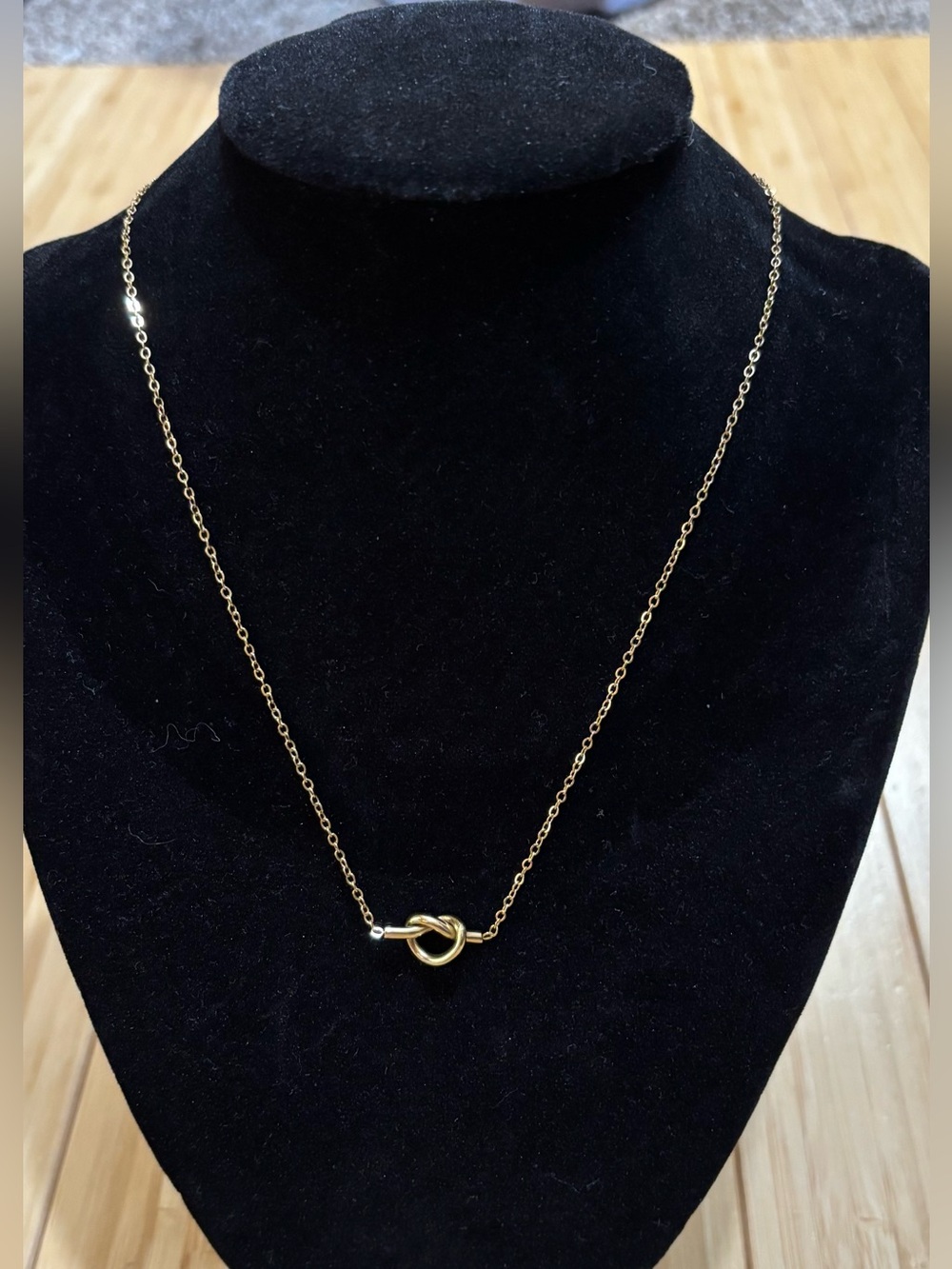 gold-toned chain necklace featuring a delicate tie-knot pendant. NWT (packaging)